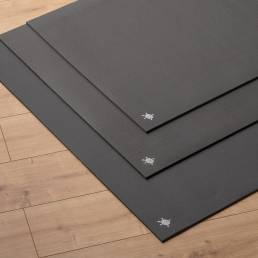 Kurma Black Grip yoga mats 3 sizes stacked on wooden floor