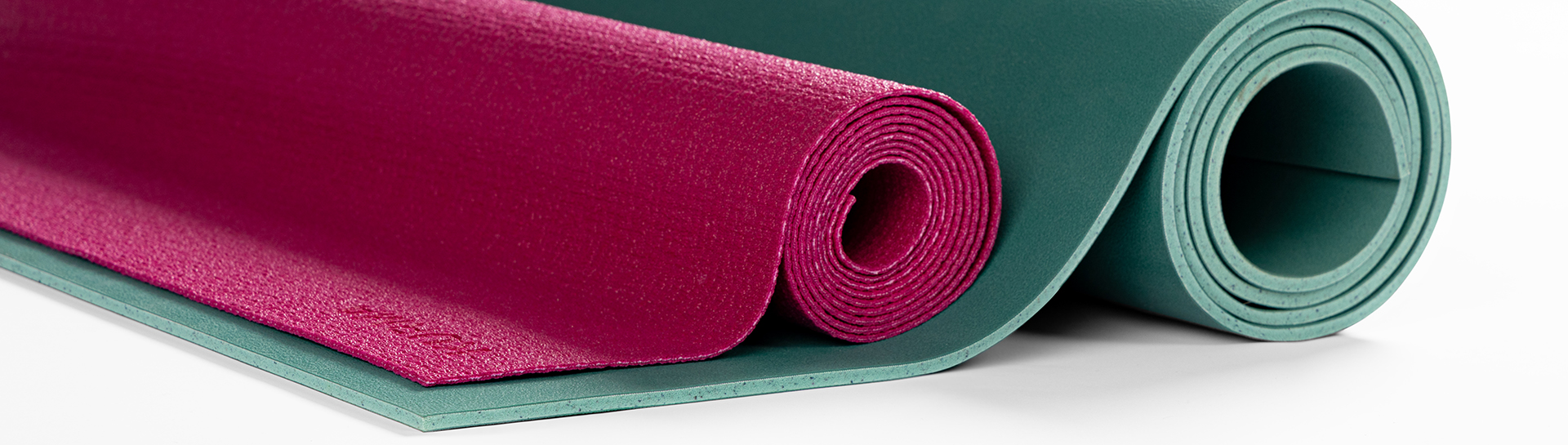 Rolled up KURMA Fold-N-Flow mat next to a KURMA GECO thick mat, to get a sense of a mat thickness