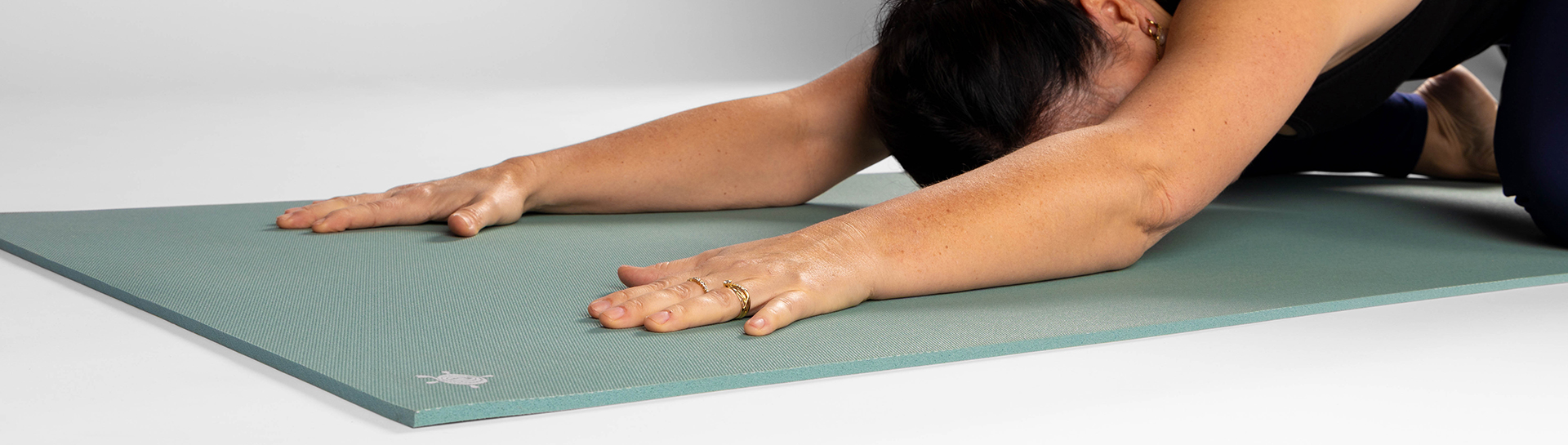 Yogini in child pose enjoying the extra cushioning of a KURMA CORE Glacier Bay yoga mat